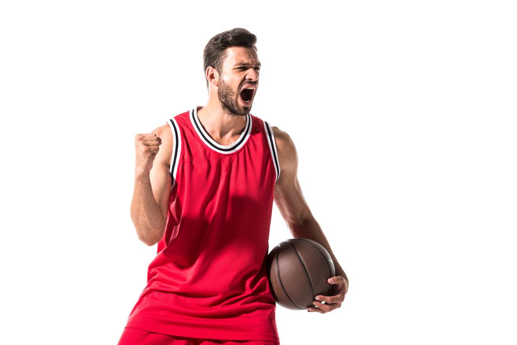 παίκτης μπάσκετ με στολή με μπάλα ζητωκραυγάζει με σφικτό χέρι απομονωμένη σε λευκό  - Φωτογραφία, εικόνα