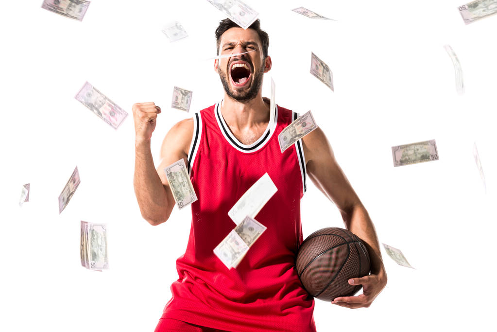 落ちるお金で白に孤立したバスケットボール選手を叫ぶ - 写真・画像