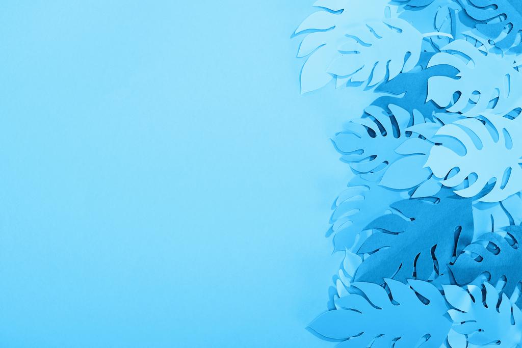 επάνω όψη των φύλλων χαρτιού σε μπλε μινιμαλιστικό φόντο με χώρο αντιγραφής - Φωτογραφία, εικόνα