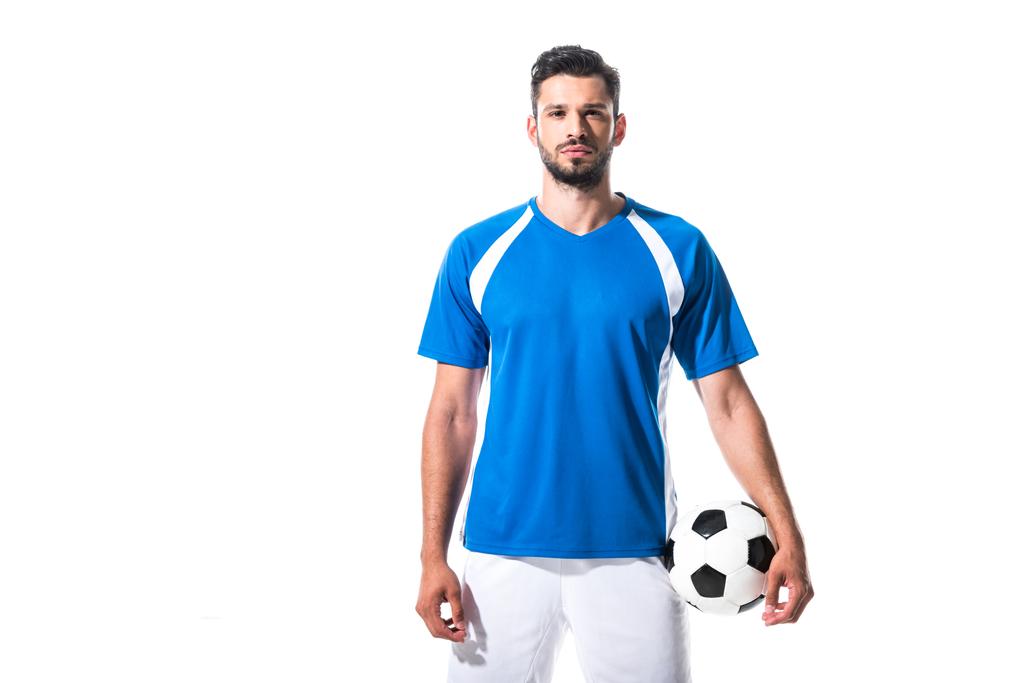 ποδοσφαιριστής κρατώντας μπάλα και κοιτάζοντας την κάμερα απομονωμένη σε λευκό - Φωτογραφία, εικόνα