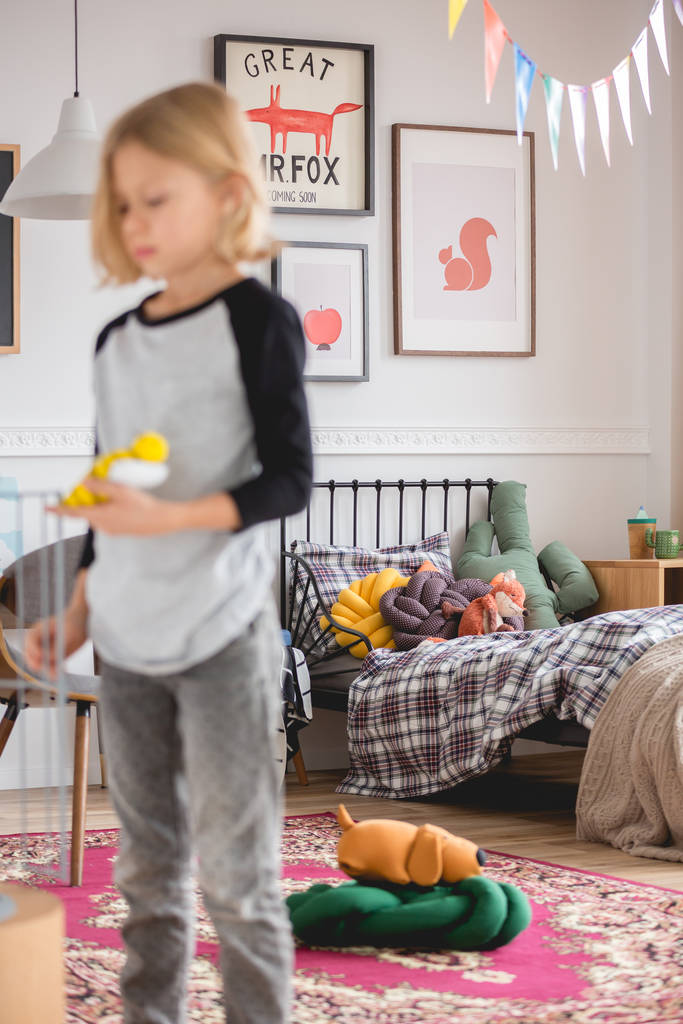 Tasarım f dolu renkli yatak odasında ayakta bulanık sarışın çocuk - Fotoğraf, Görsel