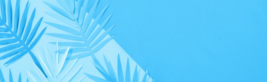 панорамный снимок листьев бумаги на синем минималистичном фоне с копировальным пространством
 - Фото, изображение