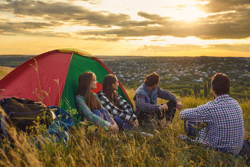 Camping tente camping personnes touristes assis au coucher du soleil dans la nature
. - Photo, image