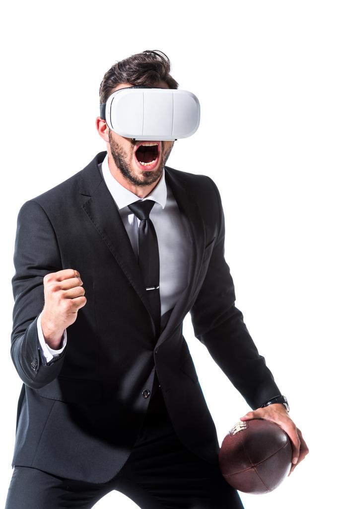 vzrušený obchodník s mikrofonem ve virtuální realitě s ragbyovou koulí a zaťatou rukou izolovaný on White - Fotografie, Obrázek