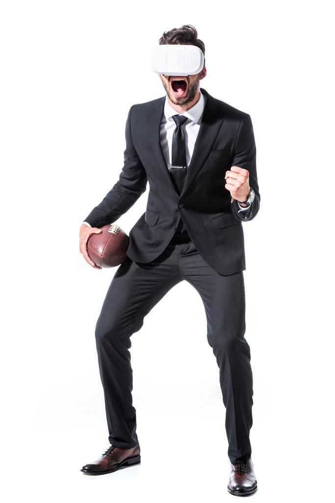 opgewonden zakenman in Virtual Reality headset met Rugby bal en gebalde hand geïsoleerd op wit - Foto, afbeelding