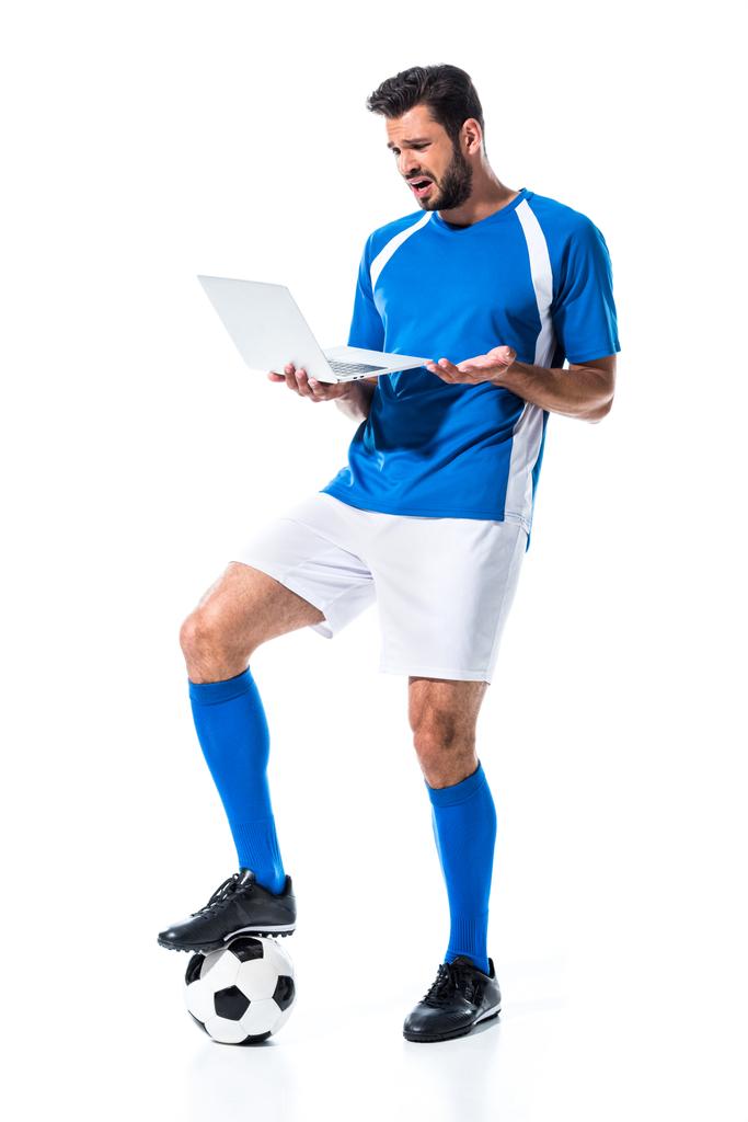 confused soccer player using laptop and standing on ball Isolated On White - Photo, Image