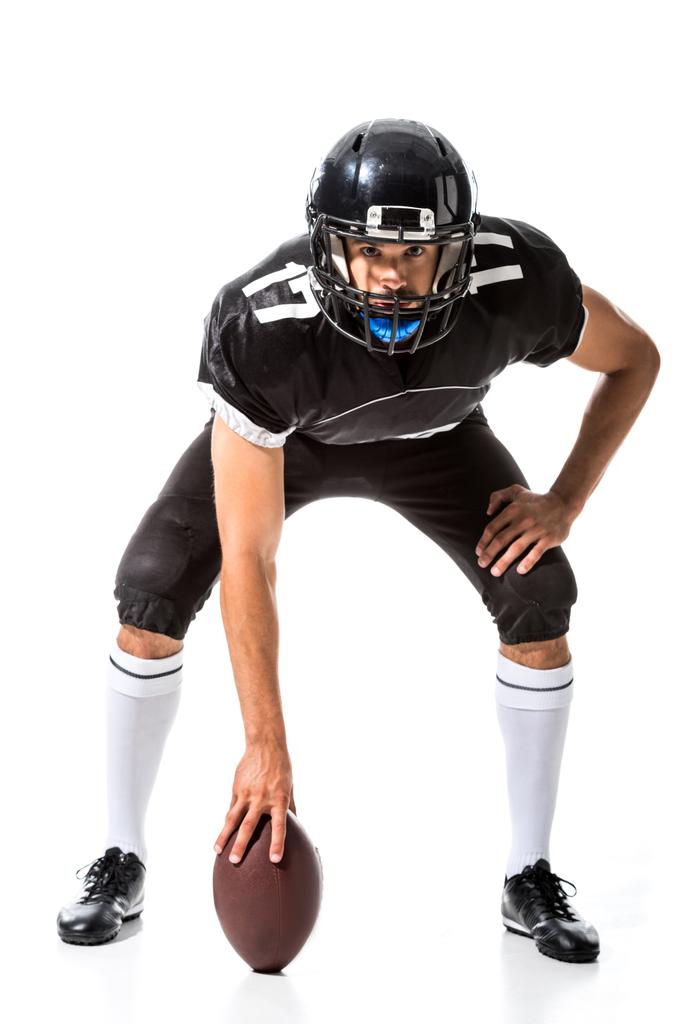 Jugador de fútbol americano sosteniendo la pelota y mirando a la cámara aislado en blanco
 - Foto, Imagen
