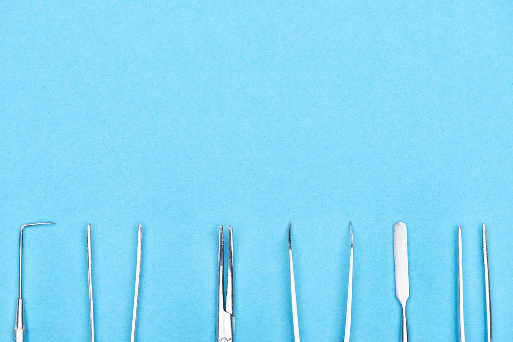 top view of set with metallic dental instruments isolated on blue  - Photo, Image