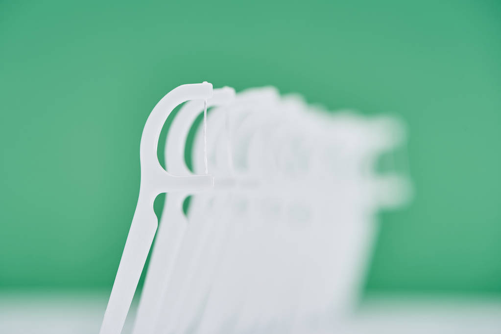 selective focus of white floss sticks isolated on green  - Photo, Image