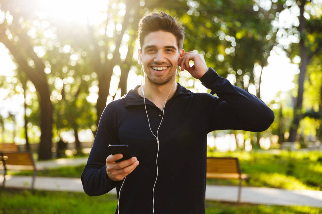 Muotokuva valkoihoinen urheilullinen mies kuuntelee musiikkia kuuloke
 - Valokuva, kuva