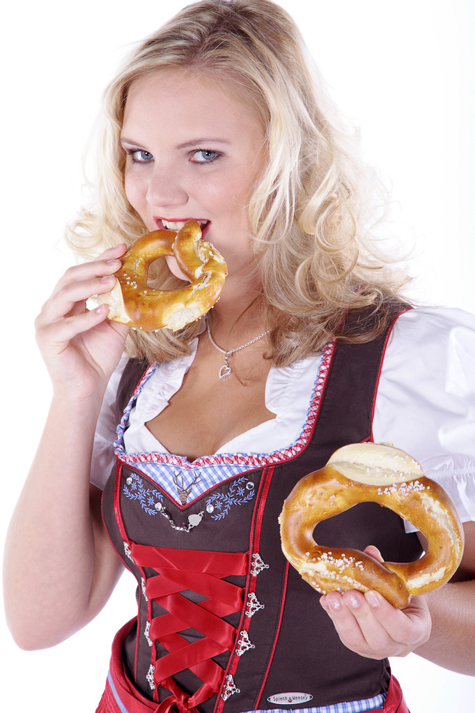 Fiatal, vonzó nő harap az Oktoberfest perec - Fotó, kép