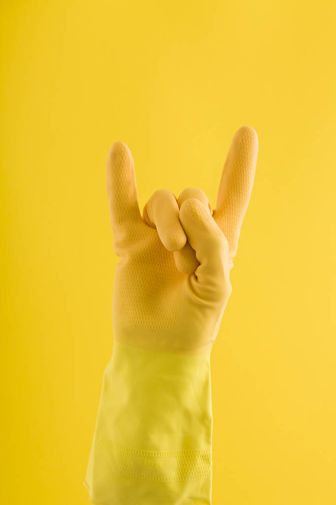Diabo chifre mão gesto feito por uma mão em um cleani borracha amarela
 - Foto, Imagem