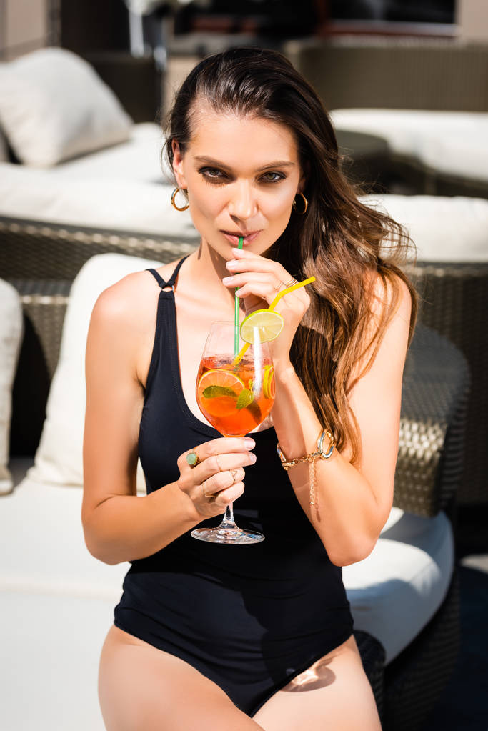attractive woman in swimming suit drinking cocktail on resort - Photo, Image