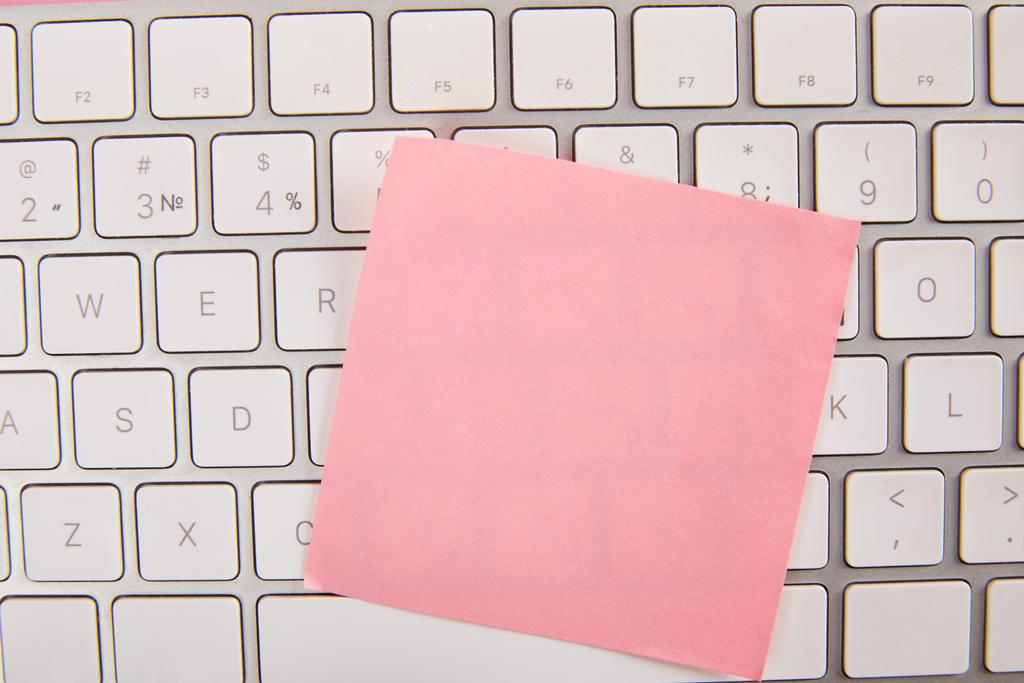 вид зверху на порожню рожеву липку ноту на клавіатурі ноутбука
  - Фото, зображення