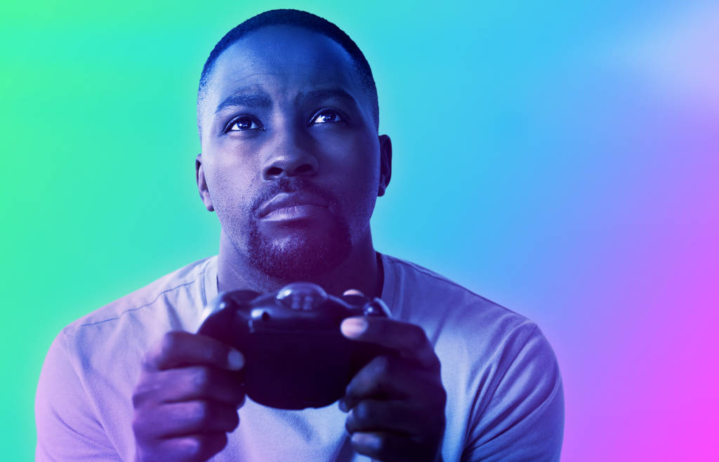 Uomo che gioca video gioco su sfondo bianco contro sfondo turchese e viola
 - Foto, immagini