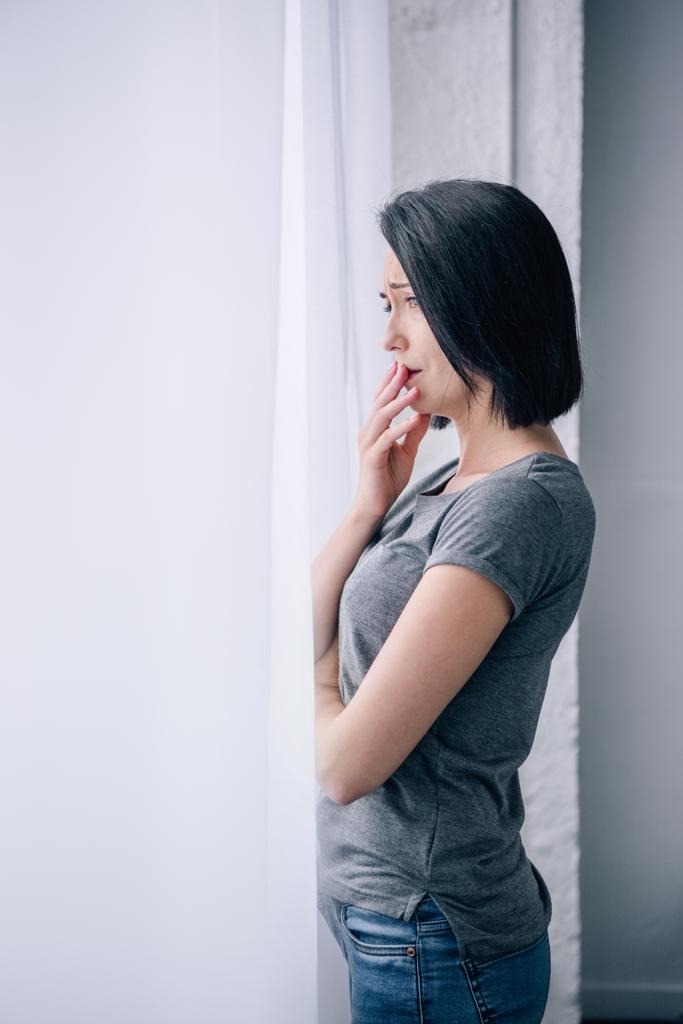 красива засмучена жінка покриває рот вдома з копіювальним простором
 - Фото, зображення