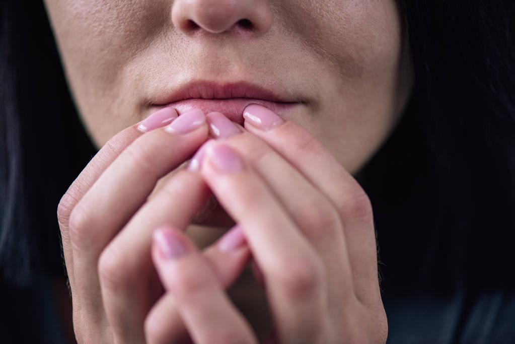 Обрізаний вид на самотню жінку, яка торкається рота вдома
 - Фото, зображення