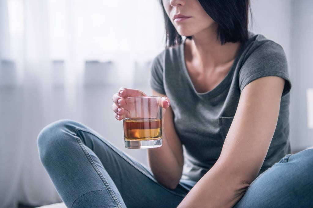 Ausgeschnittener Blick auf depressive Frau mit Whiskey-Glas zu Hause - Foto, Bild