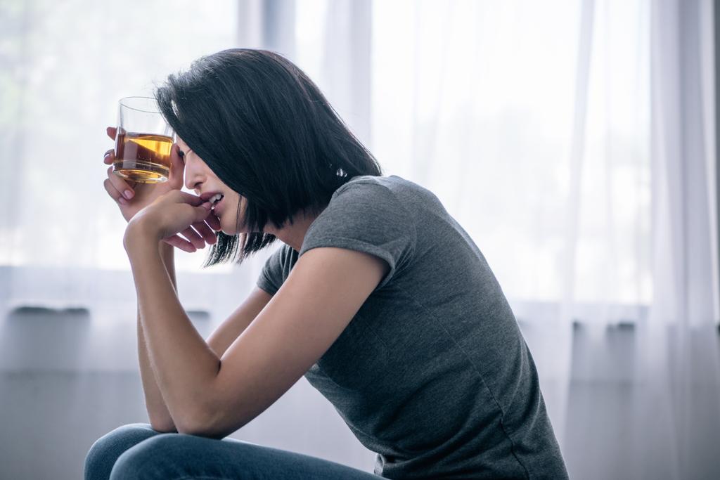rozrušená osamělá žena se sklenicí whisky doma - Fotografie, Obrázek