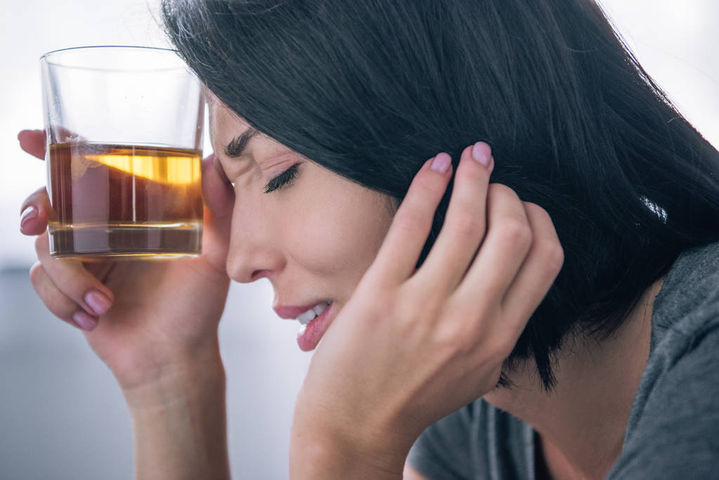 krásná rozrušená žena se sklenicí whisky doma - Fotografie, Obrázek