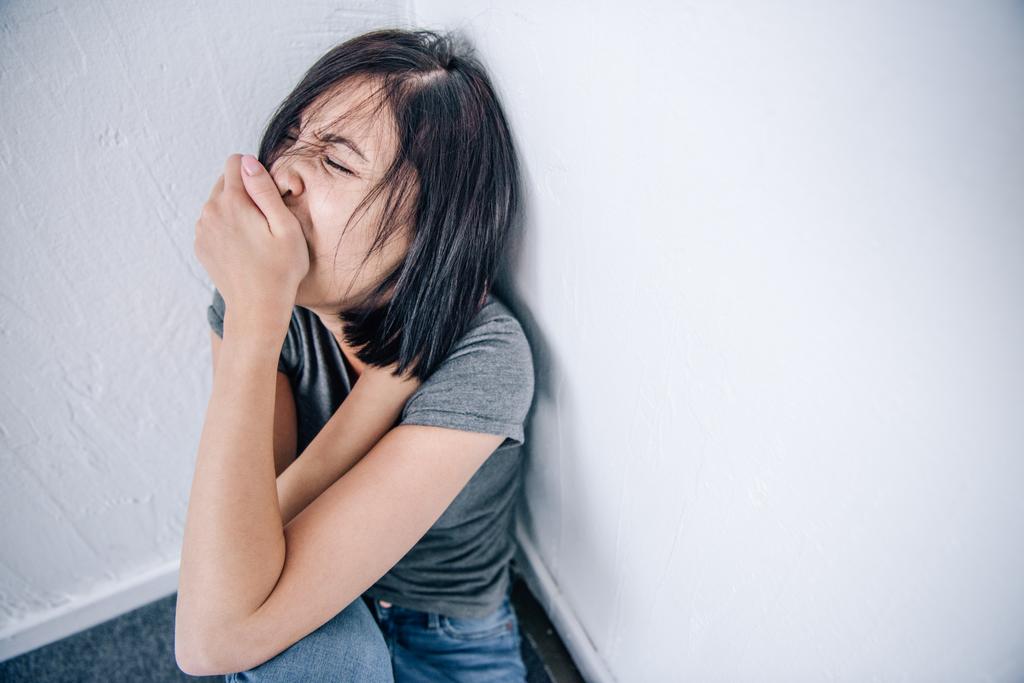 депресивна брюнетка жінка покриває рот вдома з копіювальним простором
 - Фото, зображення