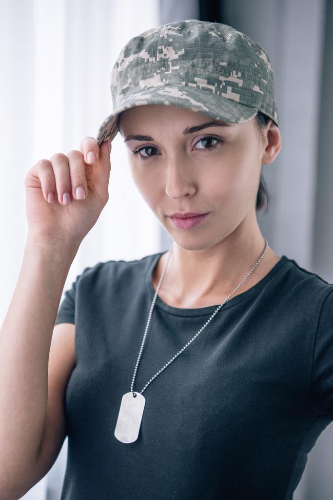 hermosa mujer en uniforme militar mirando a la cámara en casa
 - Foto, imagen
