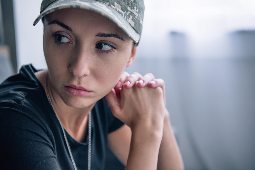 mujer deprimida en uniforme militar y gorra en casa con espacio para copiar
 - Foto, Imagen