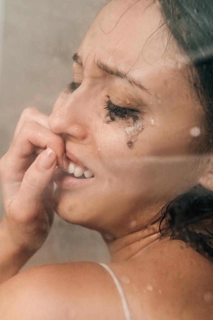 シャワーで口を覆い、自宅で泣いている孤独な落ち込んだ女性 - 写真・画像
