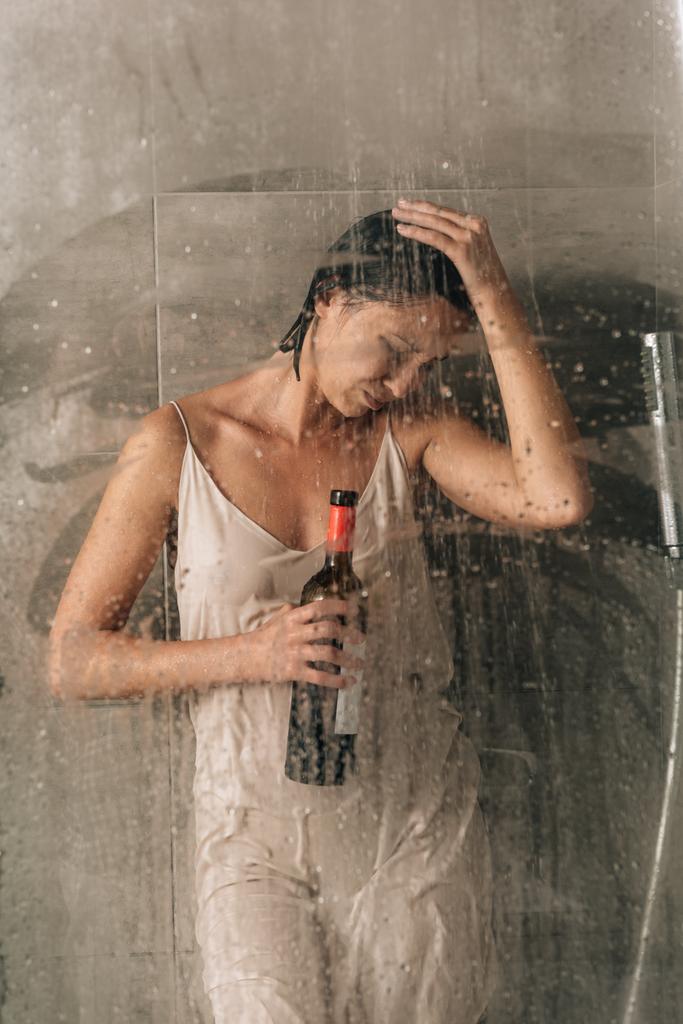 depressed woman in shower holding wine bottle and crying at home - Photo, Image