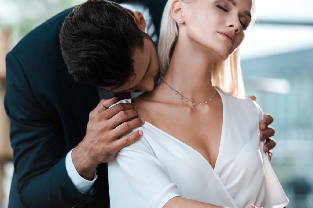 Brodaty mężczyzna całuje szyję atrakcyjne blond kobieta w biurze  - Zdjęcie, obraz