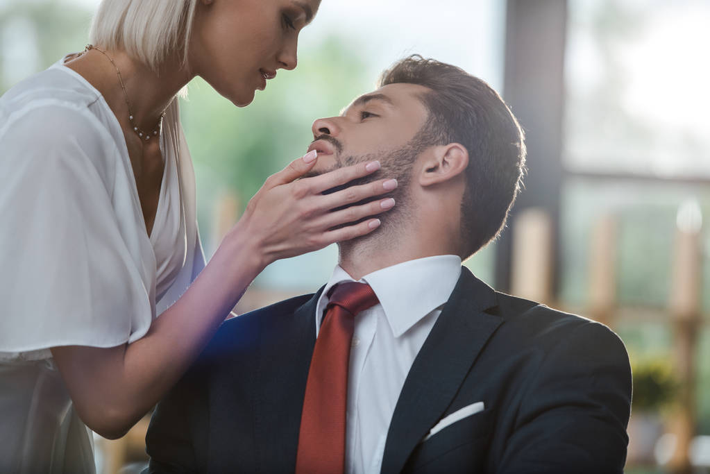 блондинка торкається обличчя бородатого бізнесмена під час флірту в офісі
  - Фото, зображення