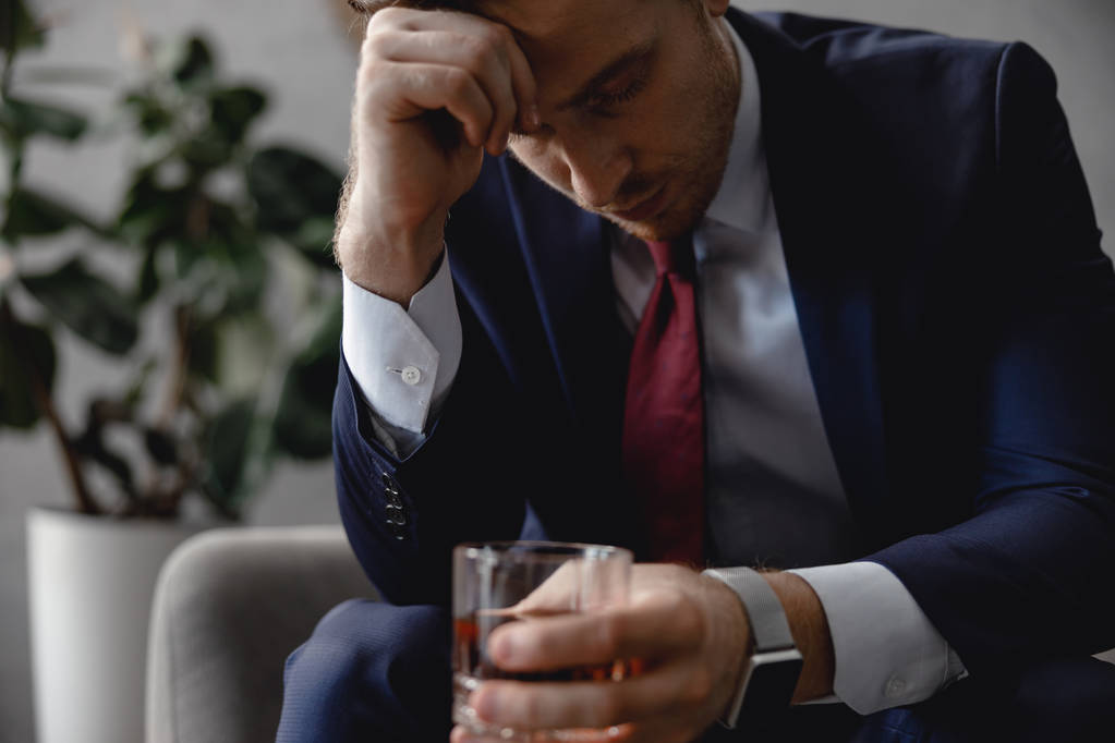 Κουρασμένος επιχειρηματίας κλείνοντας τα μάτια και κρατώντας ουίσκι - Φωτογραφία, εικόνα