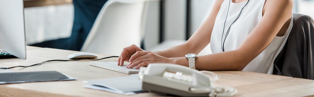 オフィスでコンピュータのキーボードを入力する女性のパノラマショット  - 写真・画像