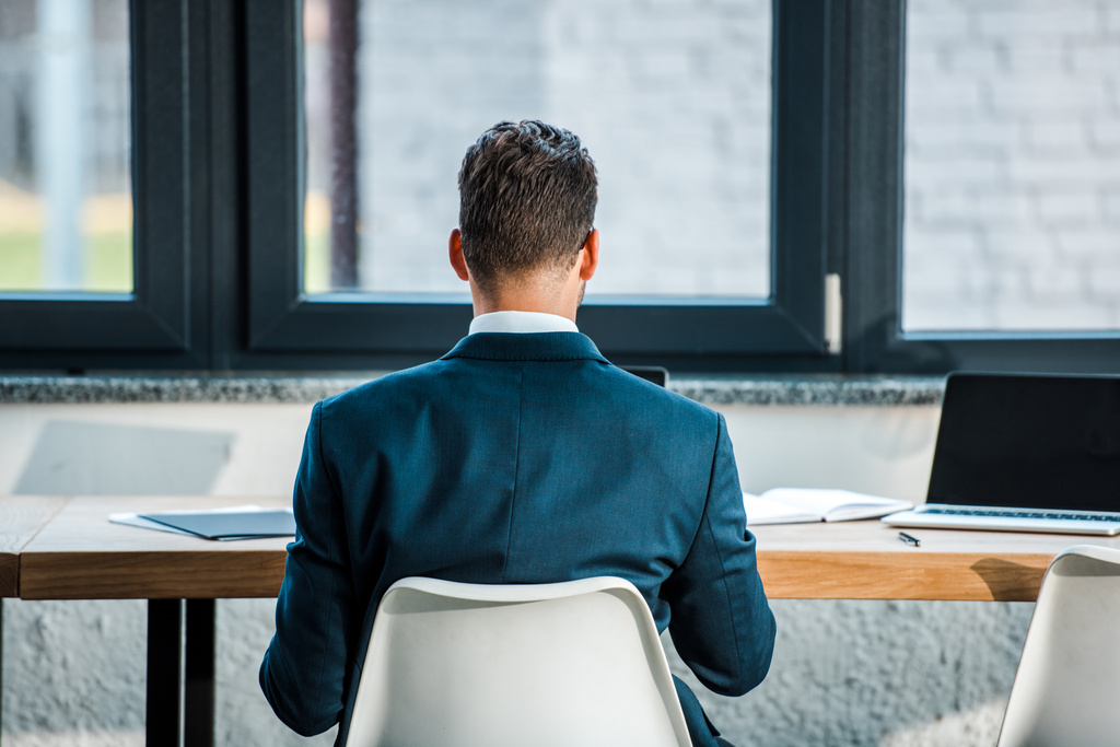 visão traseira do homem de negócios em terno sentado no escritório moderno
  - Foto, Imagem