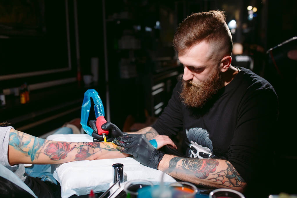 Tatuaggio artista professionista fa un tatuaggio su una mano di giovani ragazze. - Foto, immagini