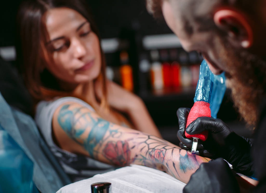 Artista de tatuagem profissional faz uma tatuagem em uma mão de meninas. - Foto, Imagem