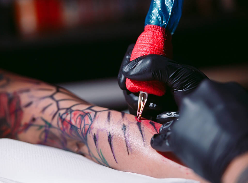 Artista de tatuagem profissional faz uma tatuagem em uma mão de meninas. - Foto, Imagem