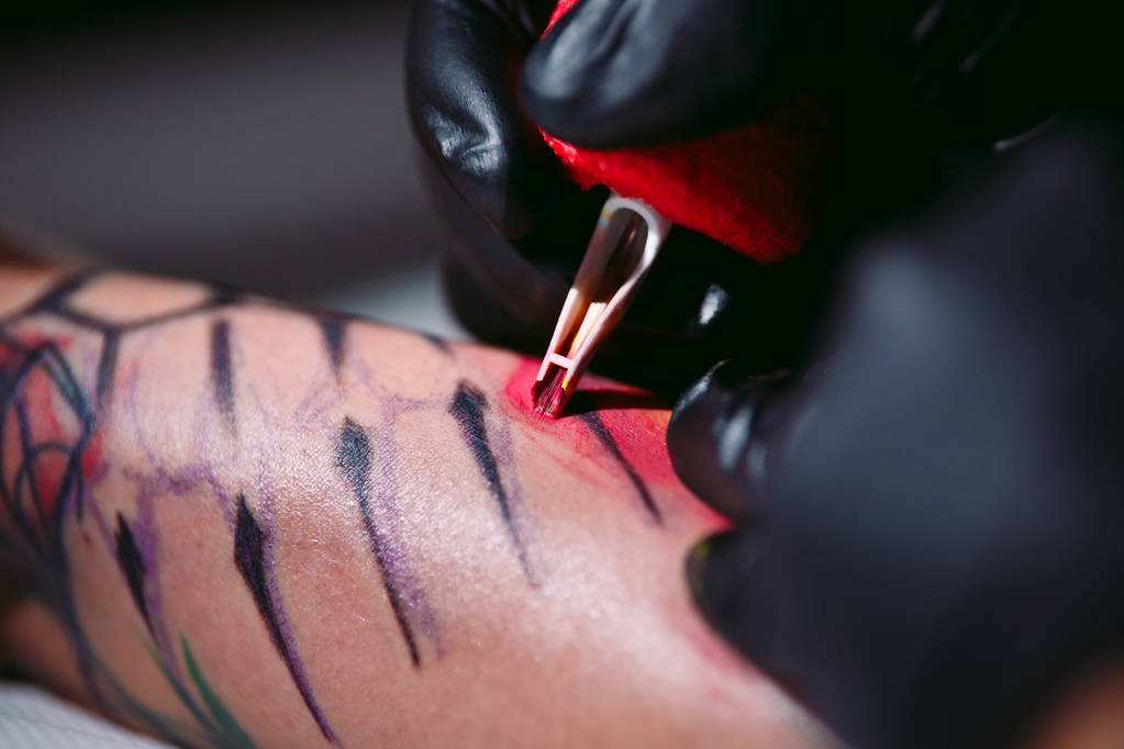 tatoueur professionnel fait un tatouage sur une main de jeunes filles. - Photo, image
