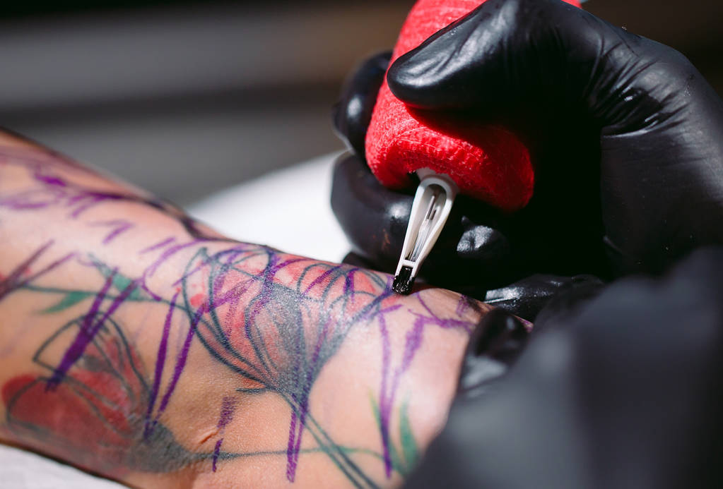 Profi tetováló művész csinál egy tetoválás egy fiatal lány kezét. - Fotó, kép