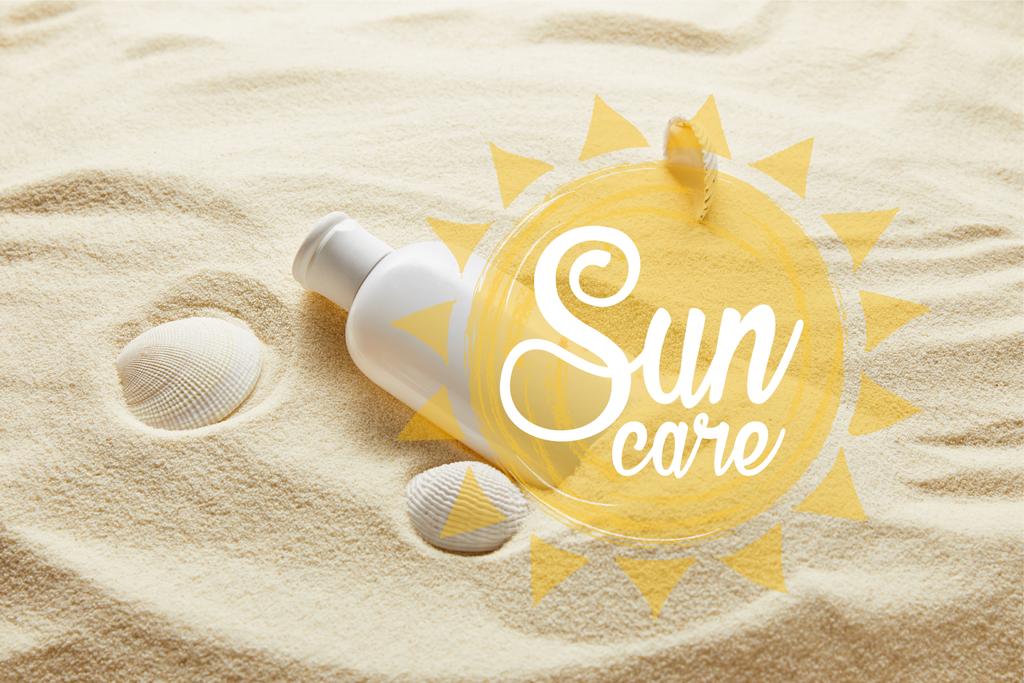 protector solar en botella blanca sobre arena con conchas marinas y letras de cuidado solar
 - Foto, Imagen