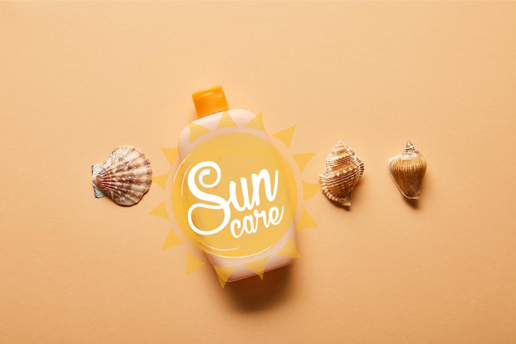 vista dall'alto di conchiglie e bottiglia con lozione abbronzante su sfondo beige con scritte per la cura del sole
 - Foto, immagini