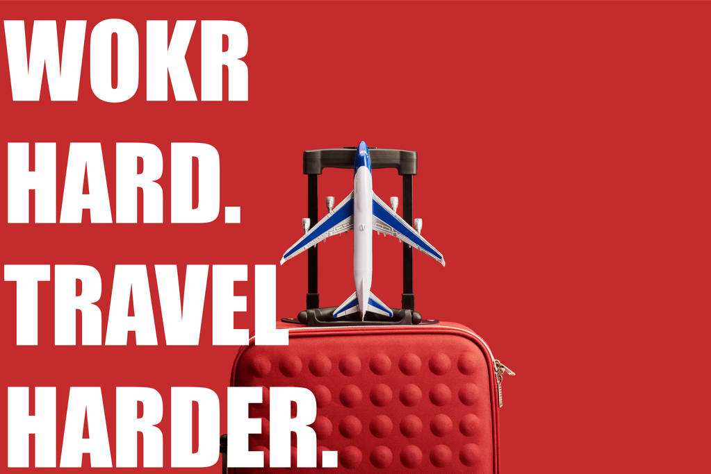 czerwony kolorowy teksturowany torba podróżna z modelem samolotu odizolowany na czerwono z ciężką pracą, podróż trudniejsza ilustracja - Zdjęcie, obraz