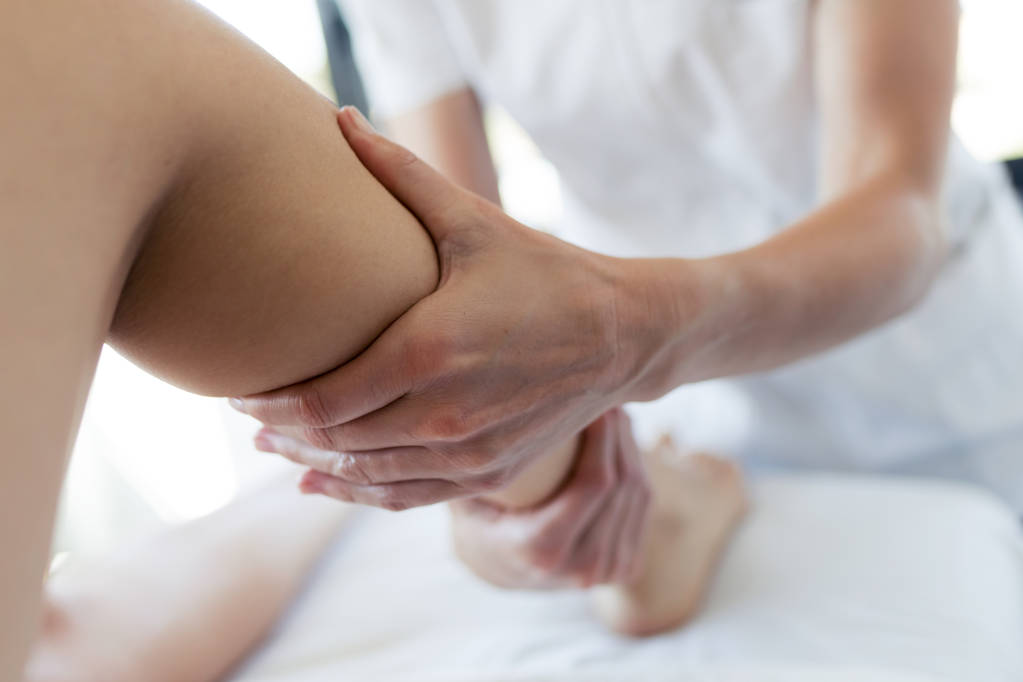 Masseur massiert die Beine der Schwangeren im Wellnesszentrum. - Foto, Bild