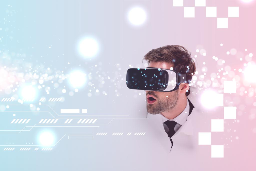 шокированный человек в гарнитуре виртуальной реальности за дырой в стене с яркой иллюстрацией киберпространства
 - Фото, изображение