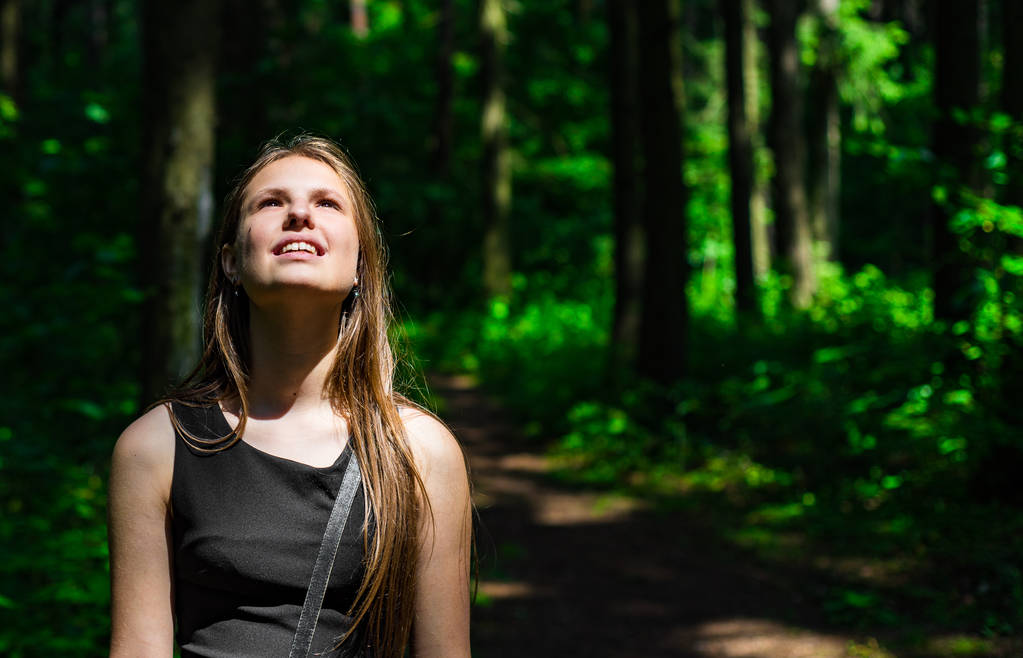 Venkovní portrét mladé teenagerové brunetové dívky s dlouhými vlasy vzhlížel v lese - Fotografie, Obrázek