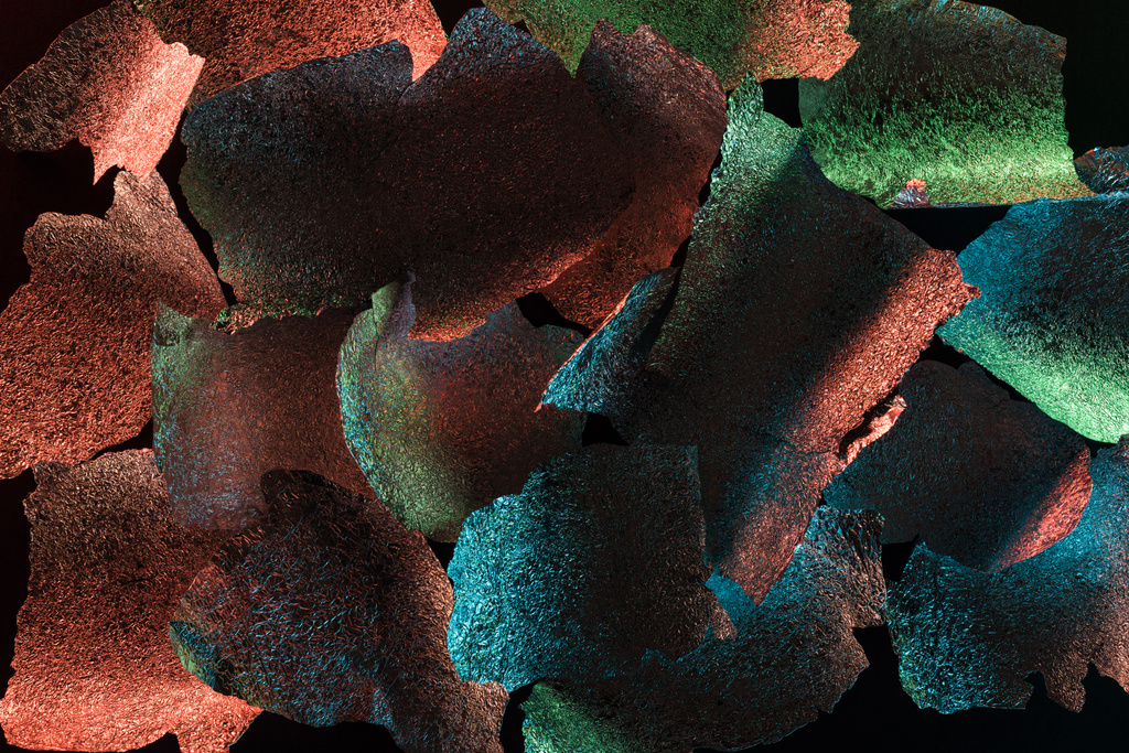 абстрактний фон з текстурованої горіхової срібної фольги з барвистим підсвічуванням ізольовано на чорному
 - Фото, зображення