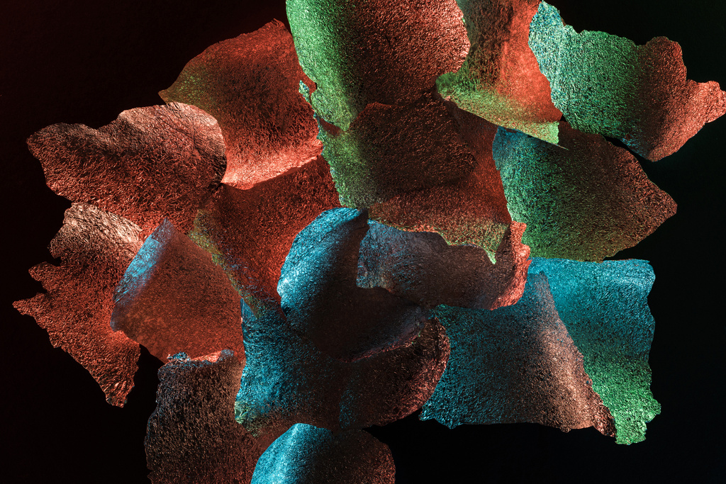 abstraktní pozadí s texturované kousky fólií s barevným osvětlením izolovaným na černém - Fotografie, Obrázek