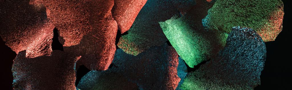 panoramic shot of abstract background of torn foil with colorful illumination isolated on black - Photo, Image