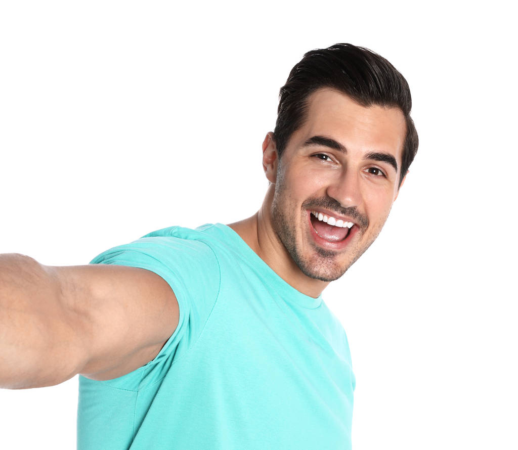 Jeune homme heureux prenant selfie sur fond blanc
 - Photo, image