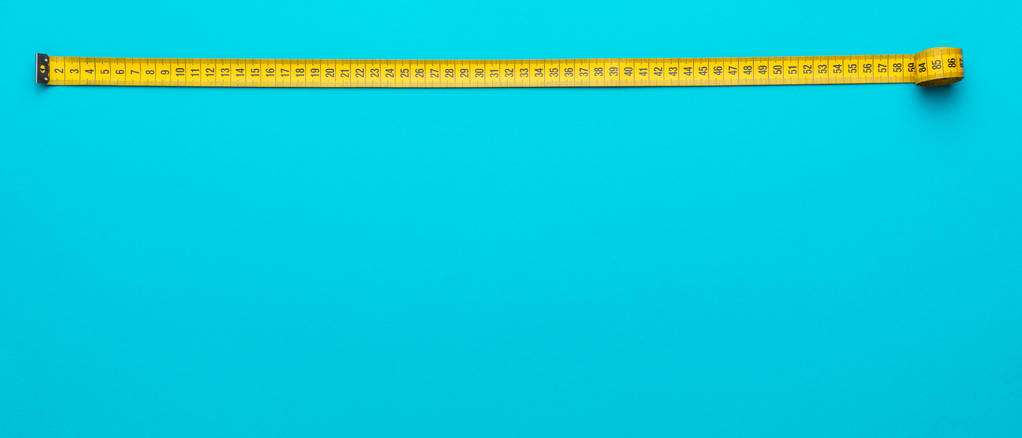 A sárga mérőszalag felülnézete türkiz kék háttérrel, másolási területtel - Fotó, kép